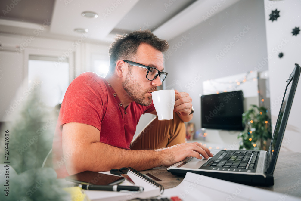 Man using laptop and drinking coffee