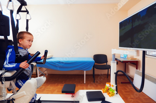 Slika na platnu young boy passes robotic gait therapy in rehabilitation center