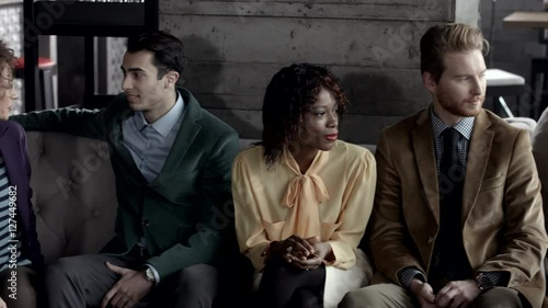 Multiethnic group of people sitting at a bar. 

