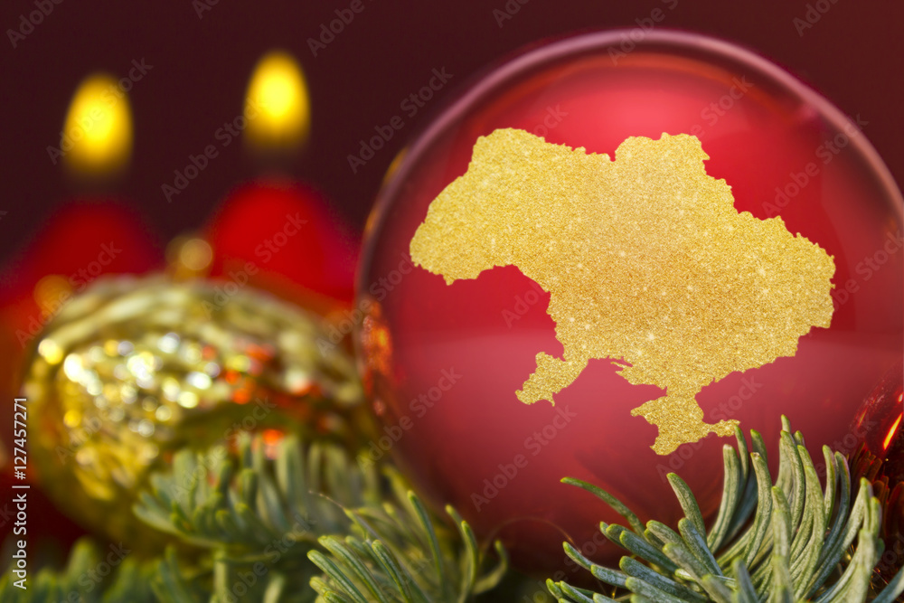 Red bauble with the golden shape of Ukraine.(series)