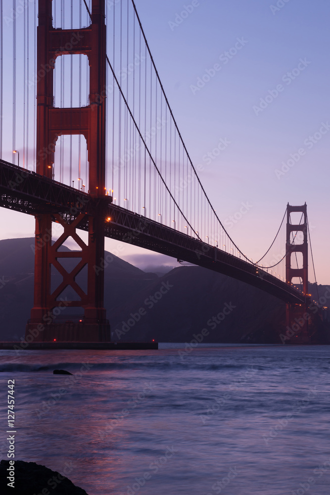 Telescope view of Golden gate bridge in evening at San Francisco bay