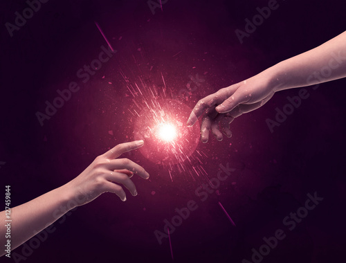 Touching hands light up sparkle in space