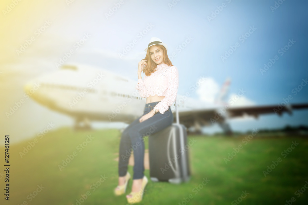 Woman asian traveler sitting on suitcase with backpack on Plane