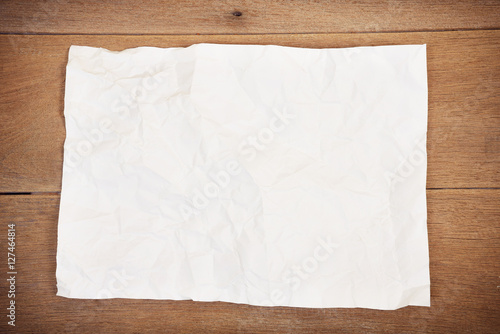 Crumpled paper sheet on a wooden background