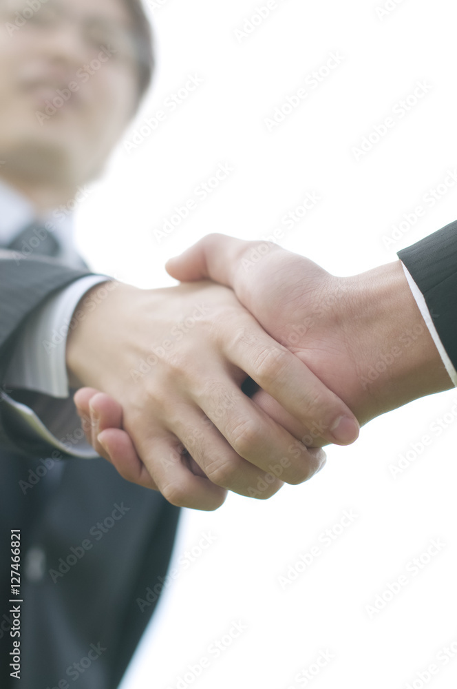 握手をするビジネスマンの手元