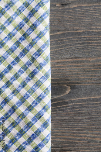 Green with blue checkered napkin on gray wooden table