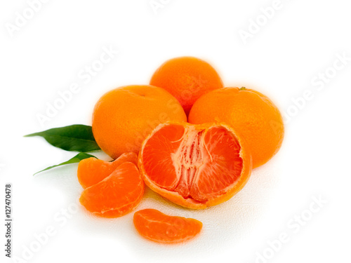 Tangerines with leaves and slices on white background