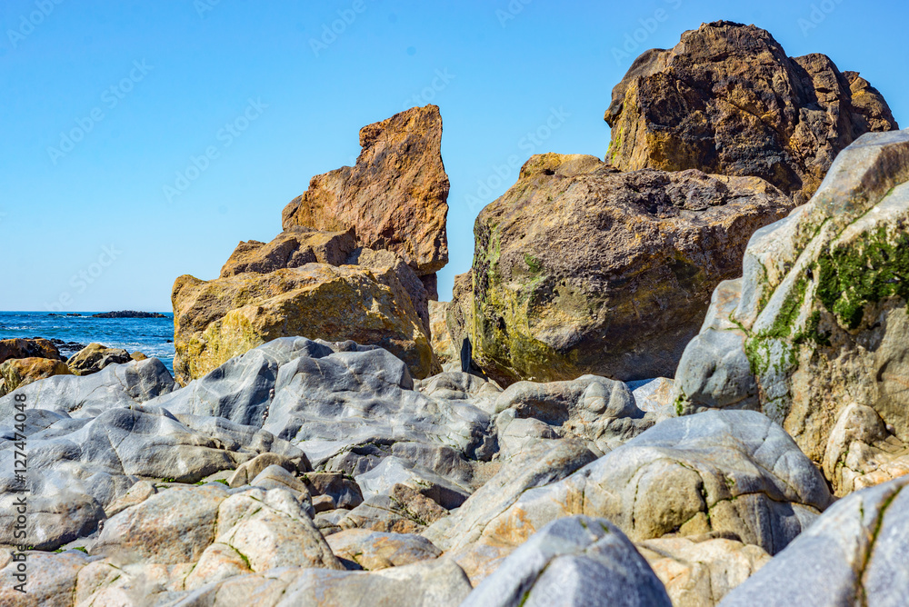 Tropical sea ocean beach bay cove rock stone pebble shore coast sunny horizon detail