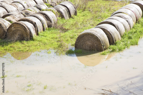 Flooded fields with wet hay bales after torrential rain