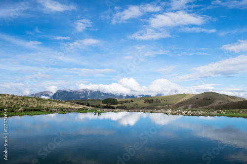 Cielo azzurro riflesso in lago di montagna