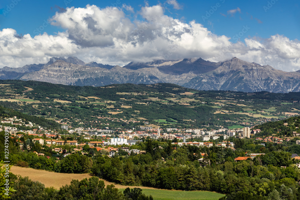 The city of Gap in the Hautes Alpes with surrounding mountains and peaks in Summer. Southern French Alps, France