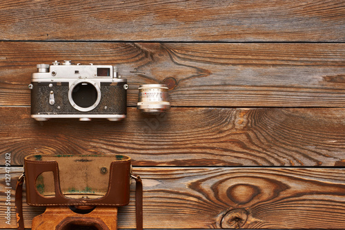 Vintage old camera and lens on wooden background