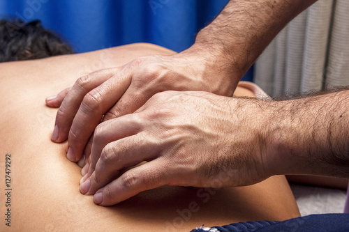 Fisioterapeuta trabajando. Quiromasajista terapéutico trabajando. Tratamiento de sobrecarga muscular.