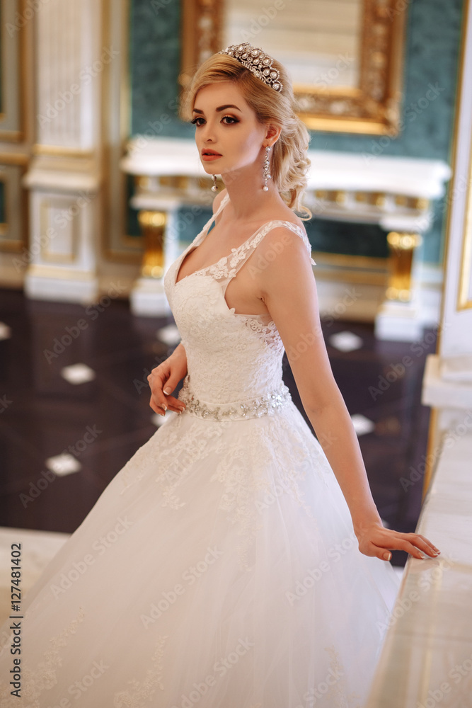 Naklejka premium beautiful young woman bride in luxury wedding dress in interior