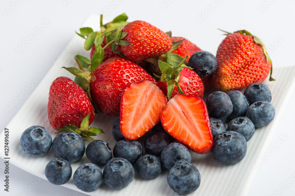 Obraz premium Fresh strawberries and blueberries on white background