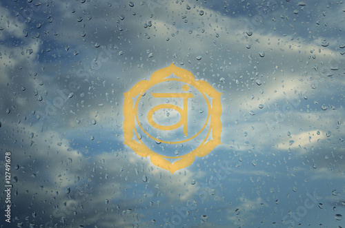 Svadhisthana chakra symbol. Poster for yoga class with a clouds photo