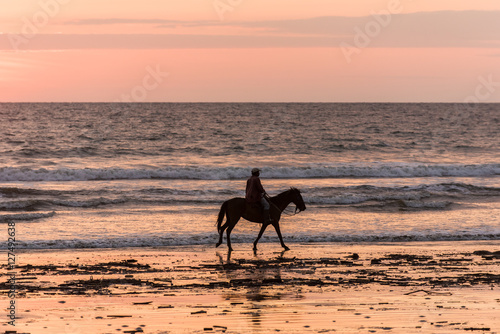 Caballero rides along Cojimies Beach in Ecuador at sunset