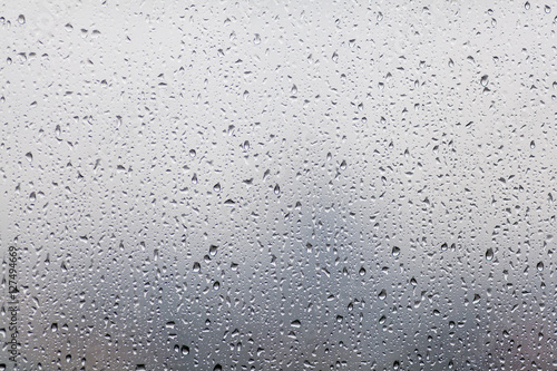 Rain drops on window glasses surface with cloudy background . Na