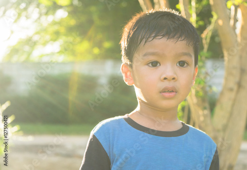 outdoor portrait of a little asian boy smiling with sunset.