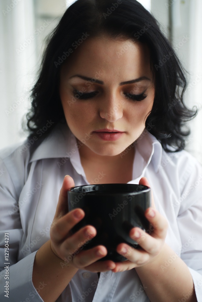Portrait of young woman holding a cup of coffee. Portrait of young woman holding a cup of coffee.