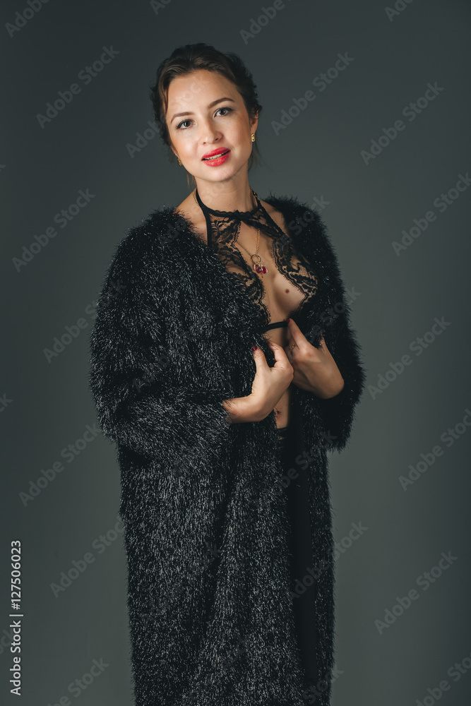 Young beautiful woman standing against black Young beautiful woman standing against black