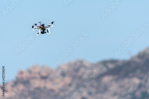 Drone with camera hovering over mountains