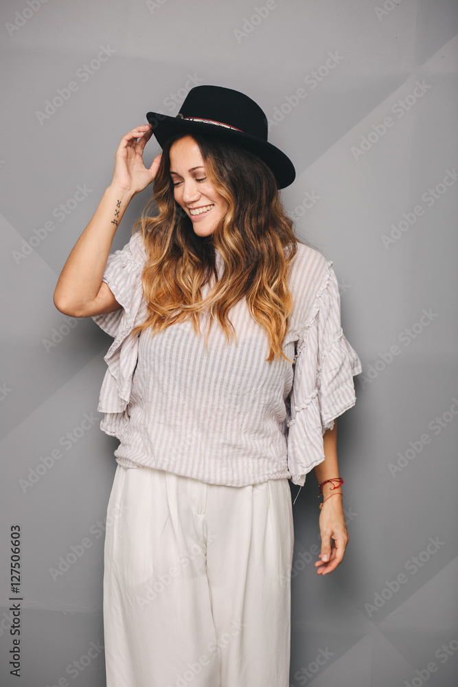 Young beautiful woman posing in white dress and black hat Young beautiful woman posing in white dress and black hat