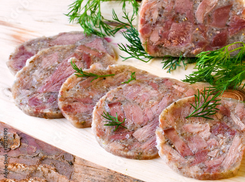 Photography Homemade headcheese with dill and cranberries on a wooden board