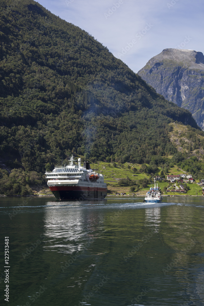 Small ship and big ferry on Norwegian fjord