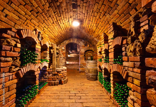 Small wine cellar with bottles and keg photo
