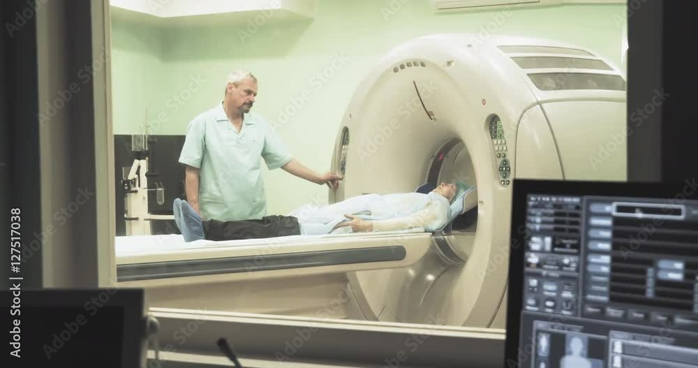 Female patient on CT MRI scanner with doctor 4k video. Computer screen with result diagnosis image. View through glass window in hospital Female patient on CT MRI scanner with doctor 4k video. Computer screen with result diagnosis image. View through glass window in hospital
