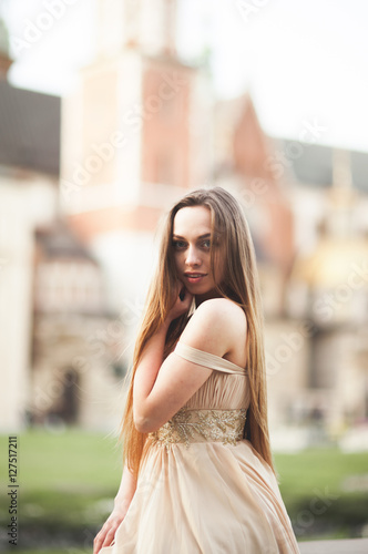 Girl in luxurious long dress on street of old town