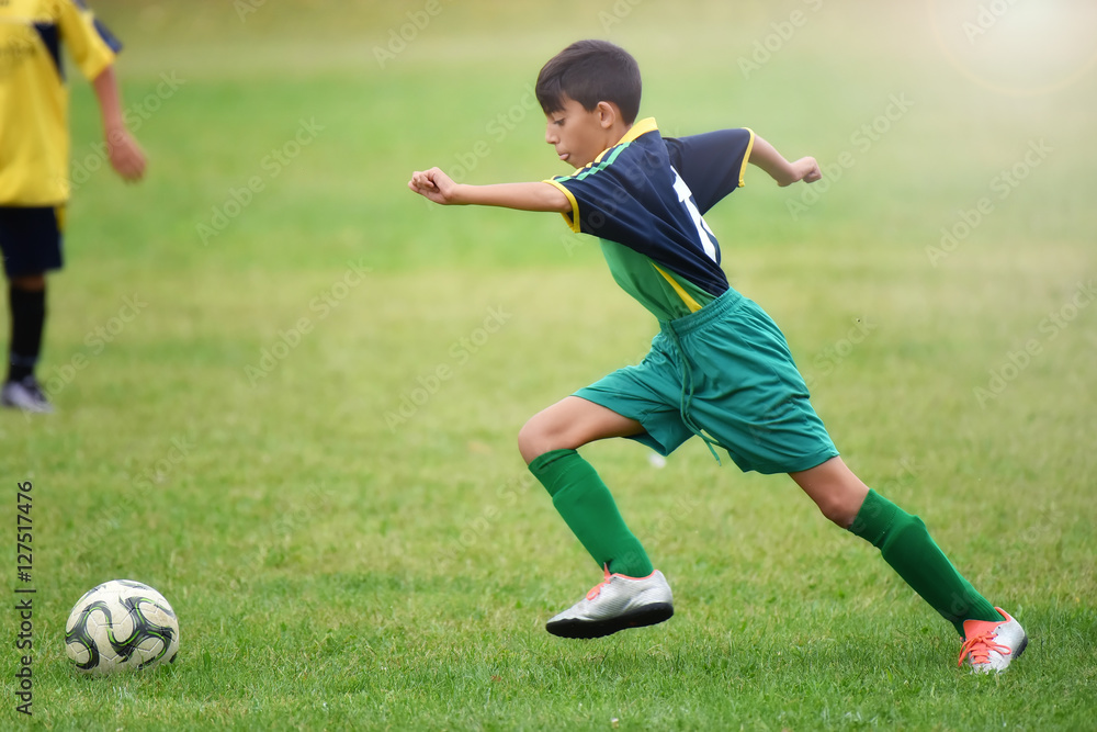 Obraz premium young boy playing soccer