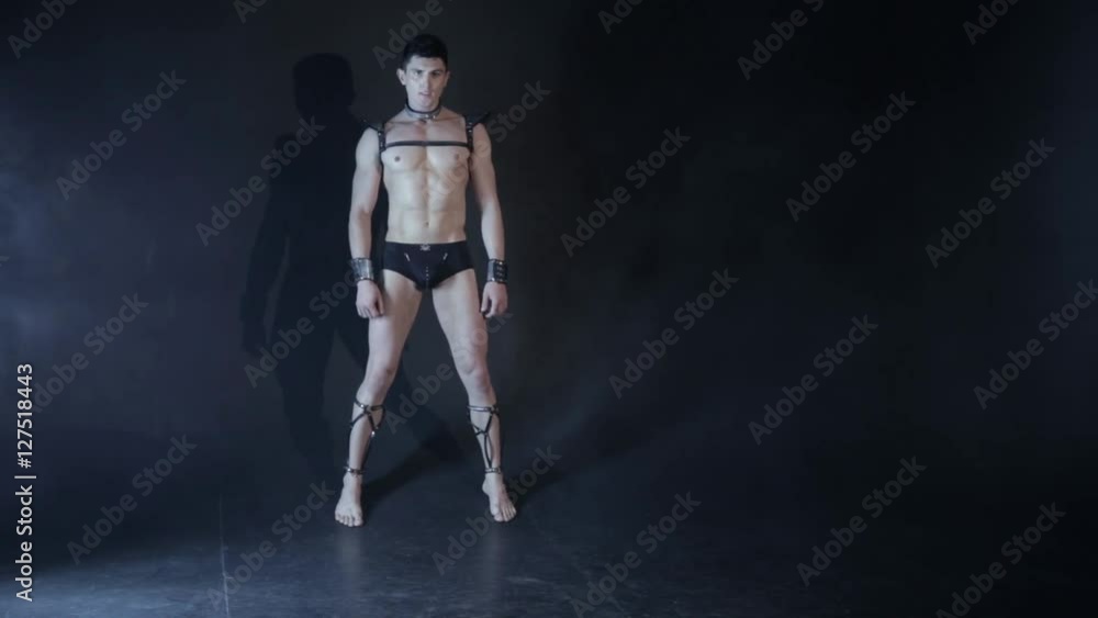Sexy muscular man dance on dark background. Beautiful body. Sex and passion. Copy space text. No color correction. Sexy muscular man dance on dark background. Beautiful body. Sex and passion. Copy space text. No color correction.
