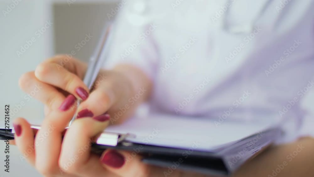 Close-up of hands of the nurse who is filling in the clinical record Close-up of hands of the nurse who is filling in the clinical record