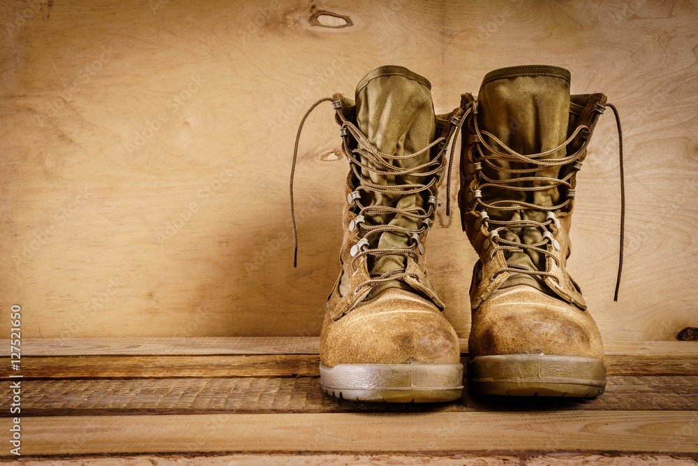 old brown military boots on a wooden table