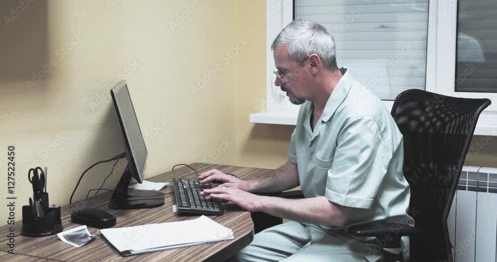 Doctor working at the computer 4k video. Medic looking at monitor typing on keyboard. Hospital clinic health care concept Doctor working at the computer 4k video. Medic looking at monitor typing on keyboard. Hospital clinic health care concept