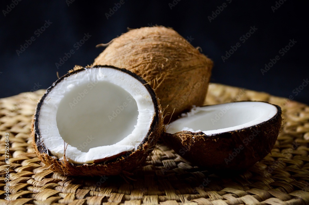 coconut on a woven surface against a black backdrop coconut on a woven surface against a black backdrop