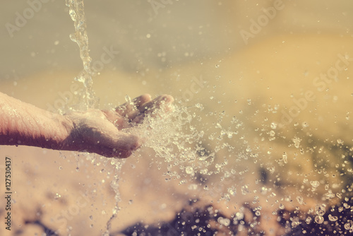 Close up of human hand catching water, ocean beach outdoors background © aquar