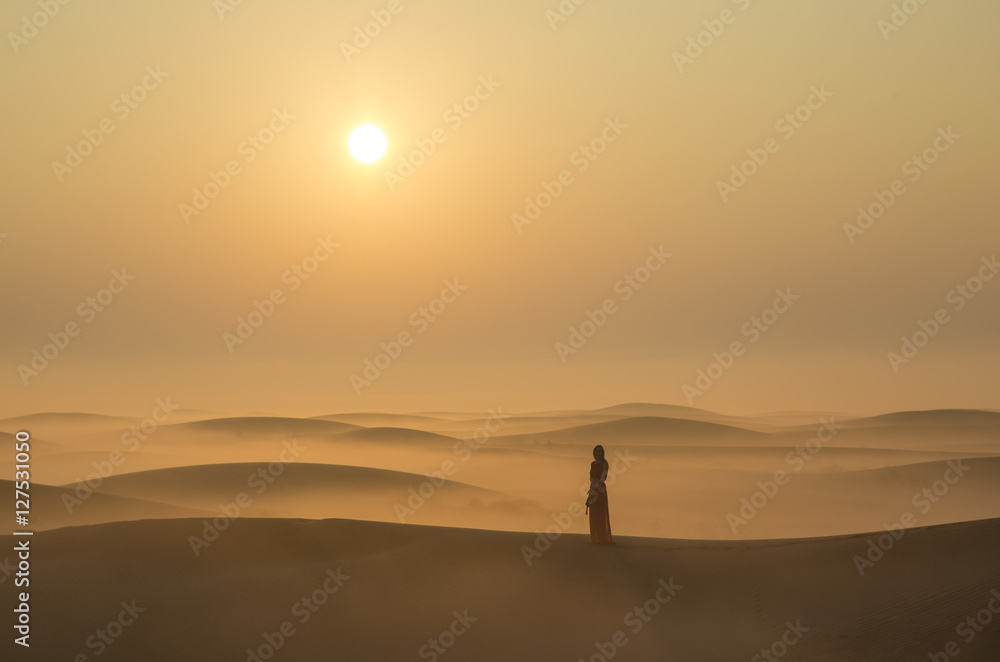 a woman in a desert at sunrise near Dubai