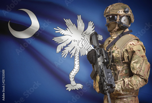 Soldier in helmet holding machine gun with USA state flag on background series - South Carolina photo