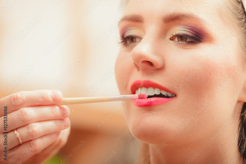 Make up artist applying lipstick with brush. Make up artist applying lipstick with brush.