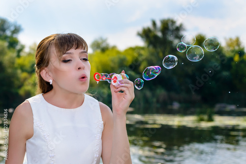 Schilderij op canvas Happy young bride blowing bubble to celebrate