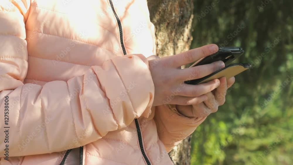 Girl viewing her photos using a mobile phone Girl viewing her photos using a mobile phone
