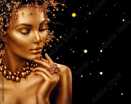 Beauty fashion model girl with golden skin, makeup and hairstyle isolated on black background © Subbotina Anna