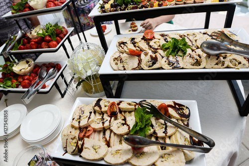 Catering service plate .appetizing sandwiches on plastic sticks rangeSandwiches on a table the buffet photo