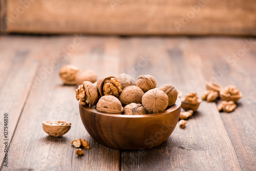 Walnuts in wooden bowl on table. Nuts.