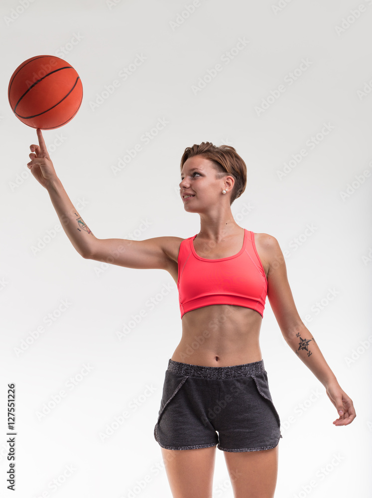 Young woman balancing a basketball on her finger
