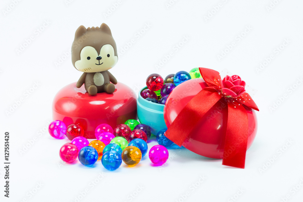 Teddy bear on red blue gift box and color plastic balls on whit Teddy bear on red blue gift box and color plastic balls on whit