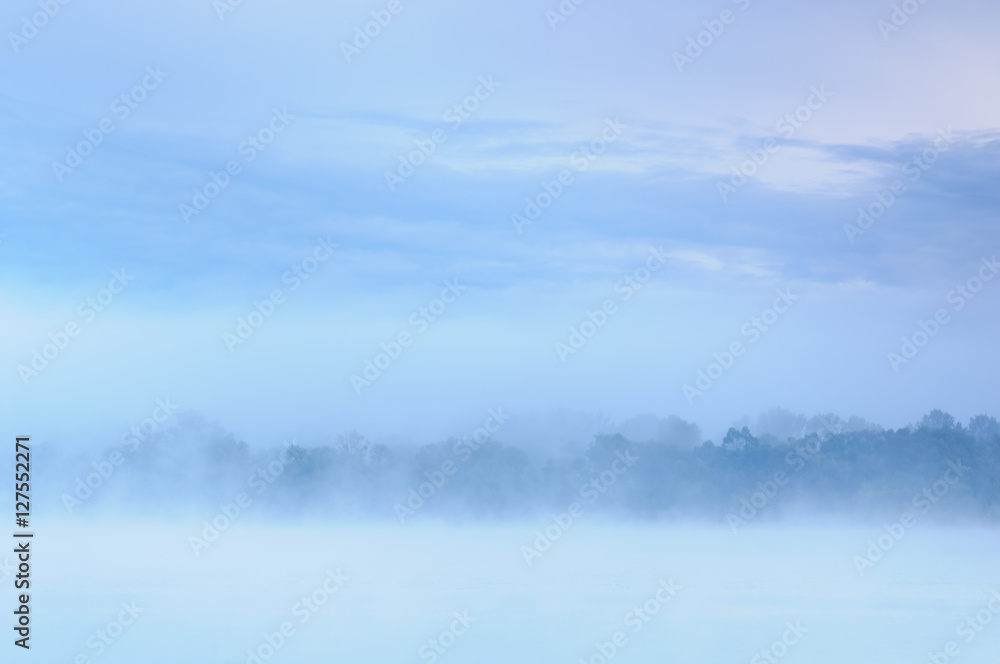 Fototapeta premium Morning over a misty blue bank of a wild river